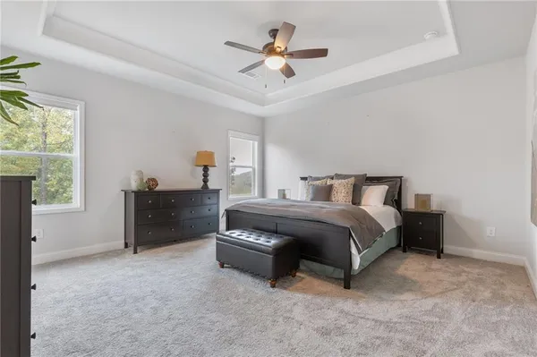 a spacious bedroom with a bed and a ceiling fan