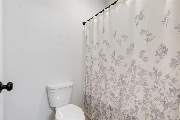 a white toilet sitting next to a shower curtain