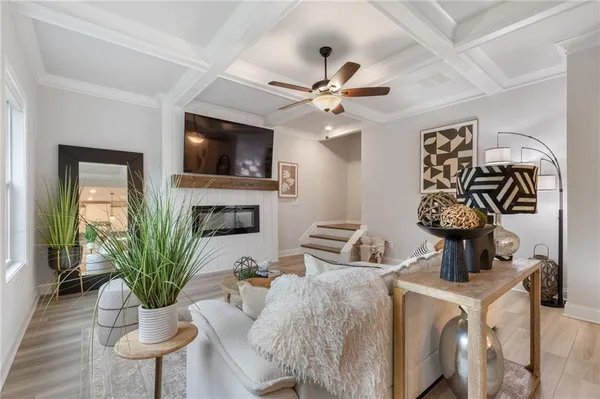 a living room with furniture a flat screen tv and a potted plant