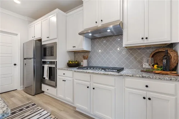 a kitchen with stainless steel appliances granite countertop a stove a sink and a refrigerator