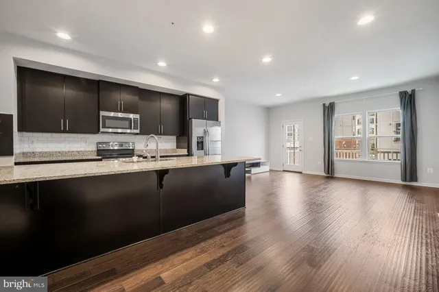 a kitchen with stainless steel appliances a refrigerator sink and microwave