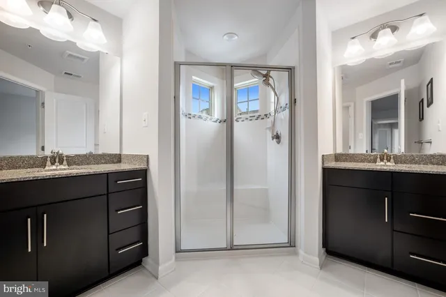 a bathroom with a granite countertop sink mirror and cabinets