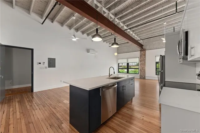 a large kitchen with stainless steel appliances granite countertop a large counter top and a wooden floors