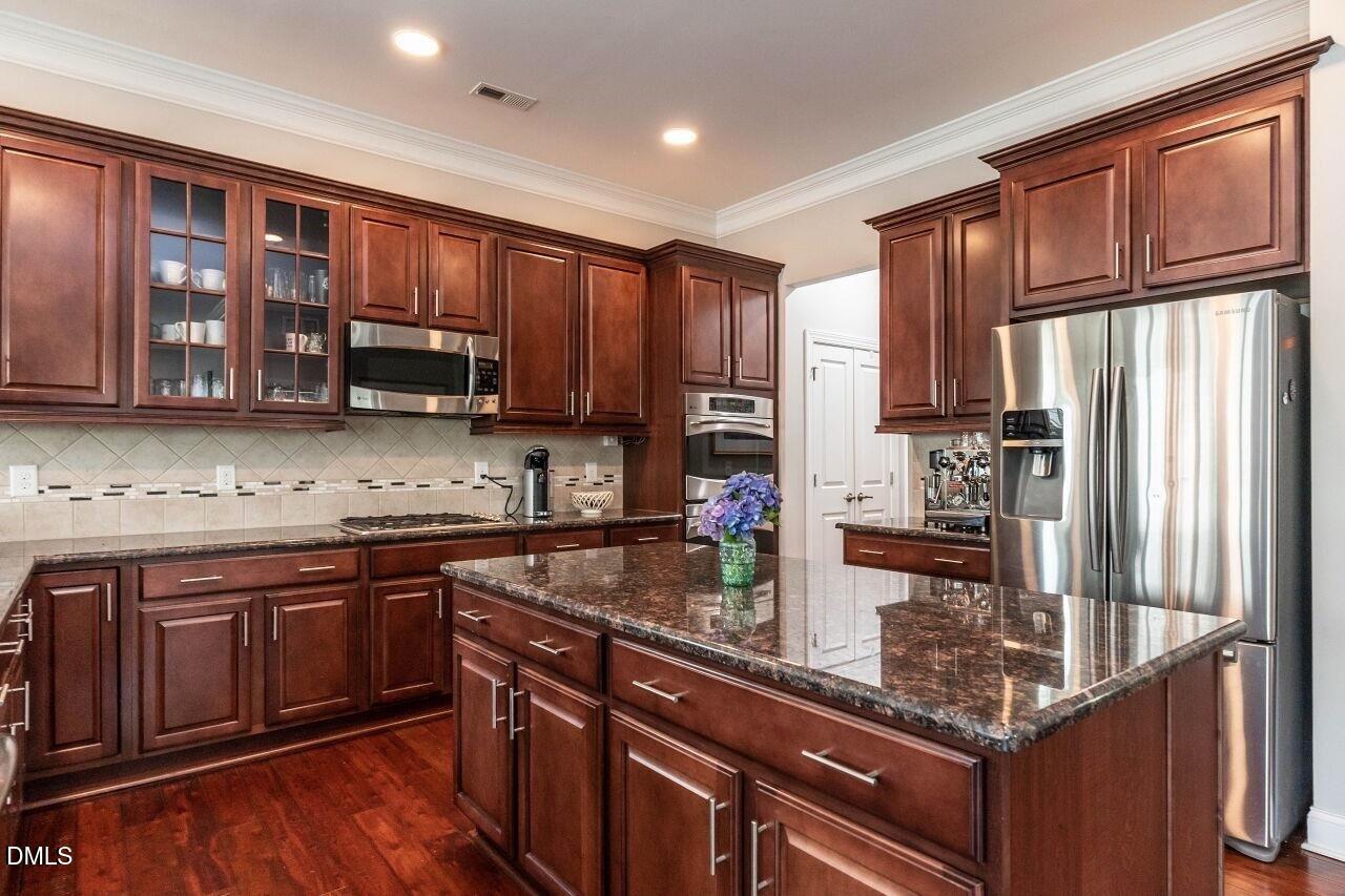 1572 Rodessa Run Raleigh, NC 27607 - Photo 10 of 39 a kitchen with stainless steel appliances granite countertop wooden cabinets a stove top oven a sink and dishwasher