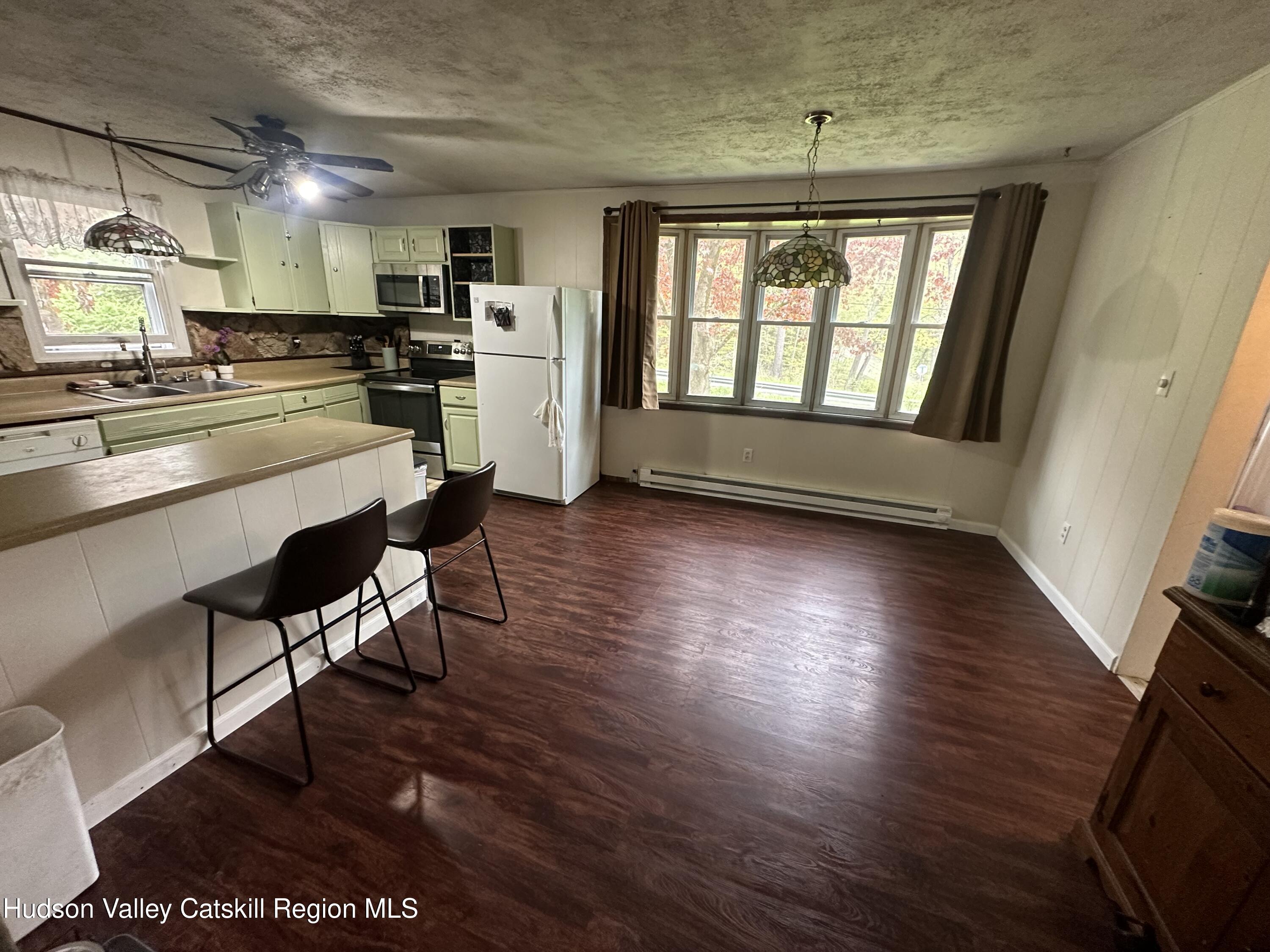1640 Co Rte 13 Brainard, NY 12024 - Photo 4 of 23 a open kitchen with stainless steel appliances granite countertop a stove a refrigerator a sink dishwasher and a fireplace with wooden floor