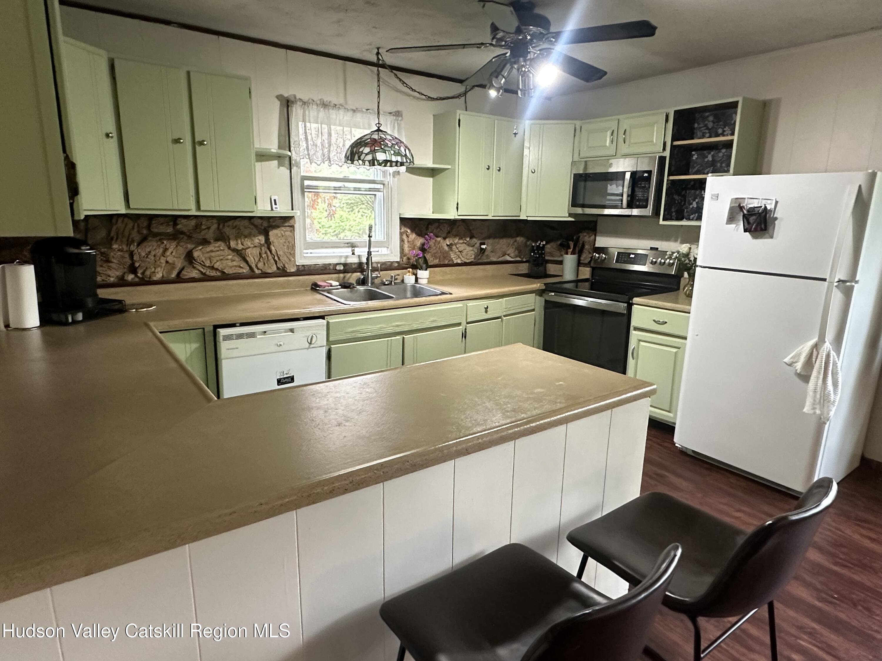 1640 Co Rte 13 Brainard, NY 12024 - Photo 5 of 23 a kitchen with stainless steel appliances granite countertop a sink a stove a refrigerator a washer dryer and white cabinets