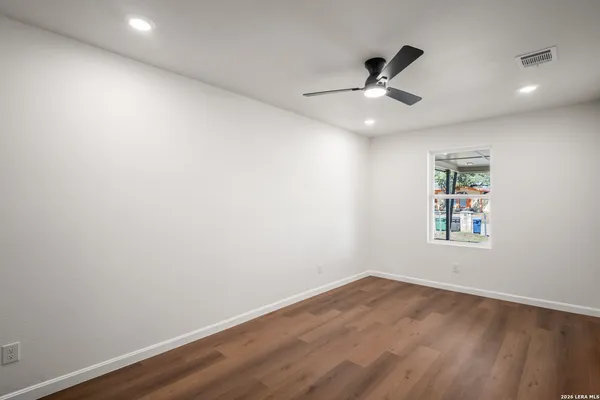 an empty room with a window and a ceiling fan