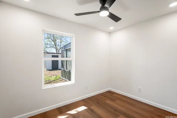 an empty room with a window and ceiling fan