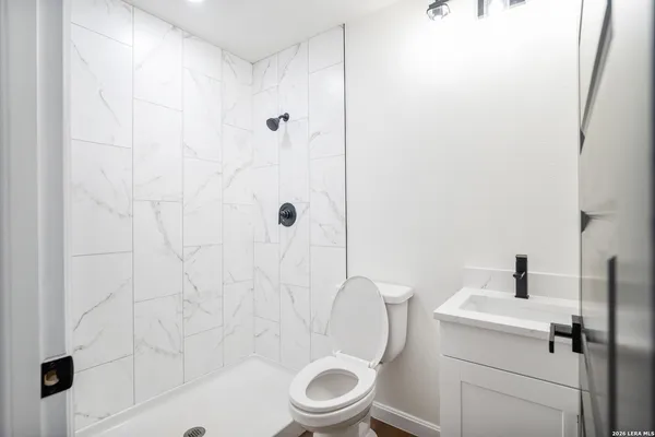 a bathroom with a sink a toilet and shower
