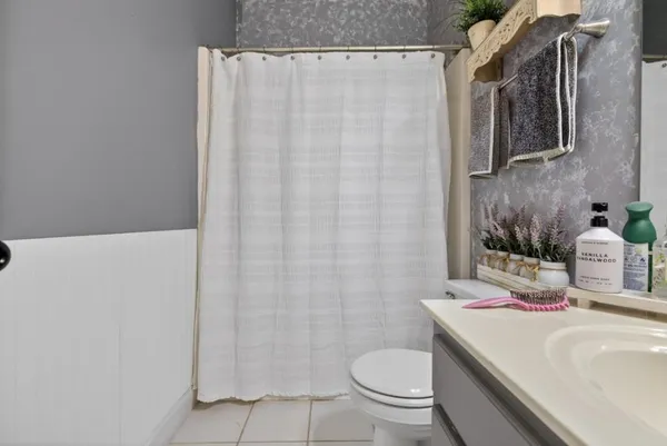 a bathroom with a toilet and a shower curtain