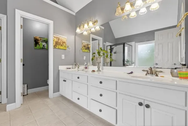 a kitchen with stainless steel appliances kitchen island a table chairs in it and white cabinets