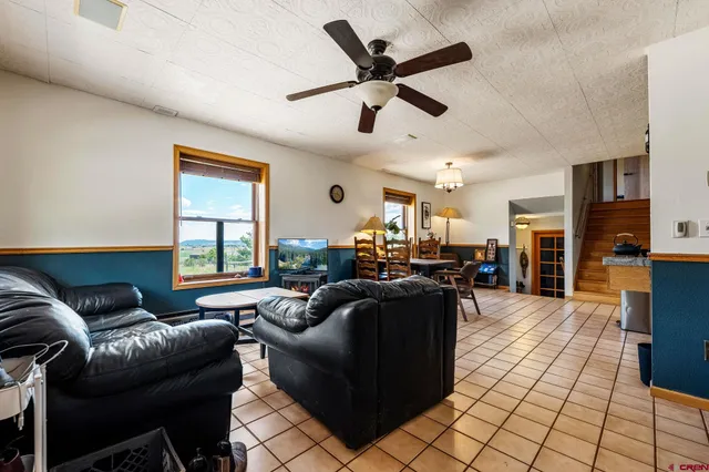a living room with furniture and a ceiling fan