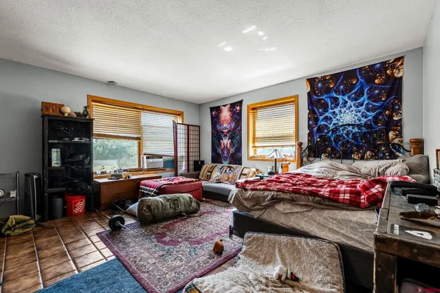 a bedroom with furniture and a large window