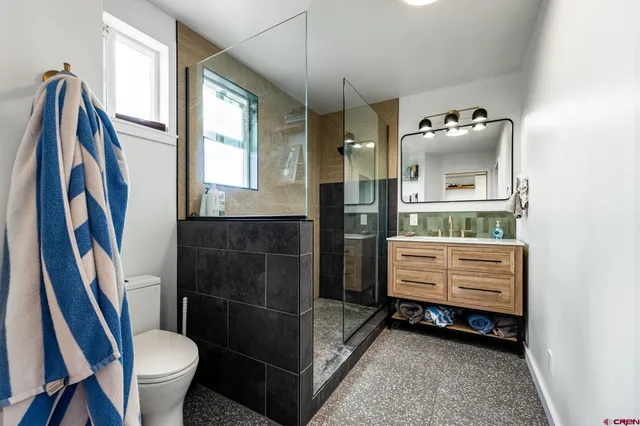 a bathroom with a sink a toilet and a mirror