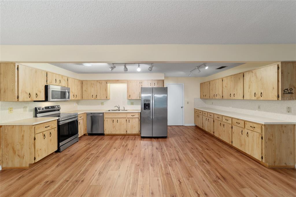 8890 Southwest 96th Street, Unit B Ocala, FL 34481 - Photo 16 of 42 a large kitchen with a lot of counter space and wooden floor