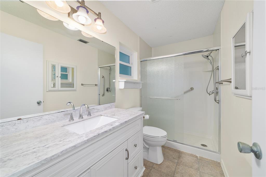 8890 Southwest 96th Street, Unit B Ocala, FL 34481 - Photo 25 of 42 a bathroom with a granite countertop sink a toilet and shower