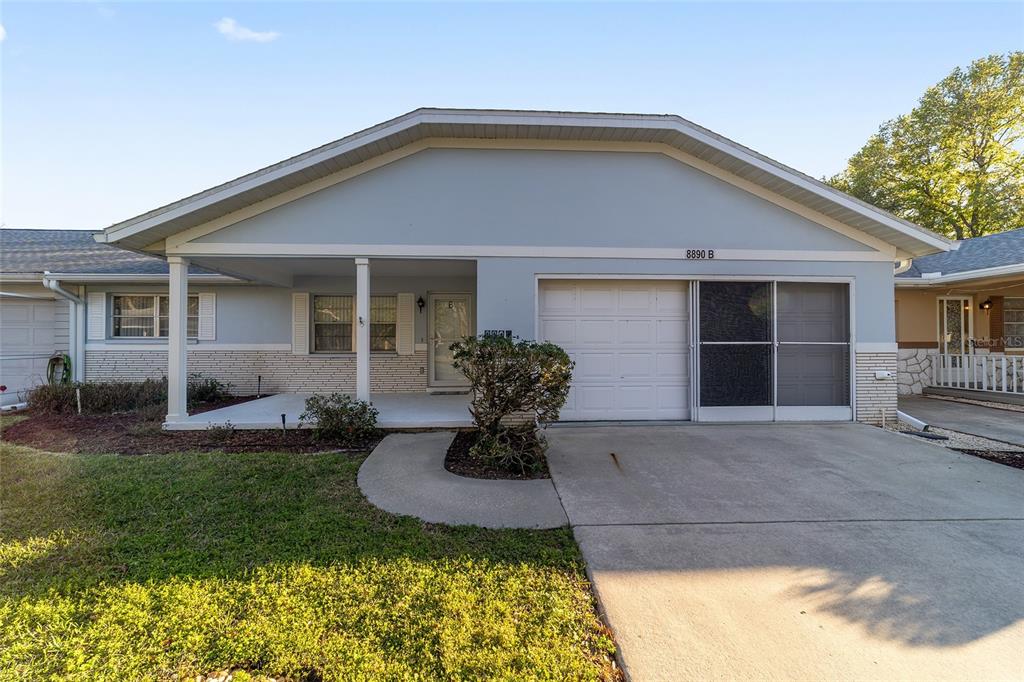 8890 Southwest 96th Street, Unit B Ocala, FL 34481 - Photo 36 of 42 a front view of a house with a yard and garage