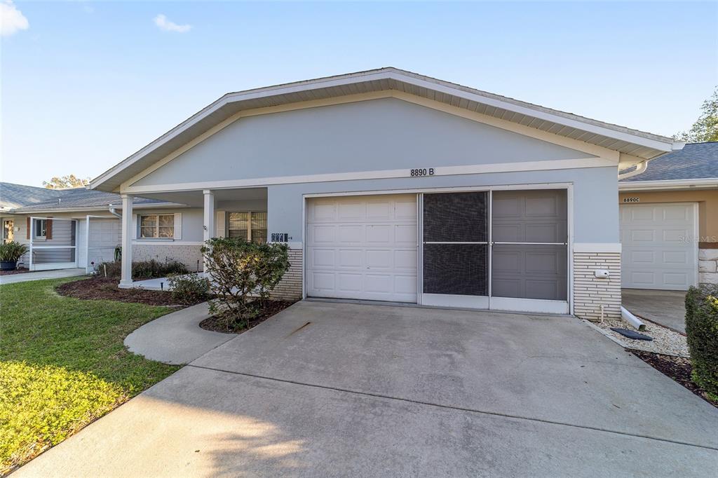 8890 Southwest 96th Street, Unit B Ocala, FL 34481 - Photo 37 of 42 a front view of a house with a garden and yard