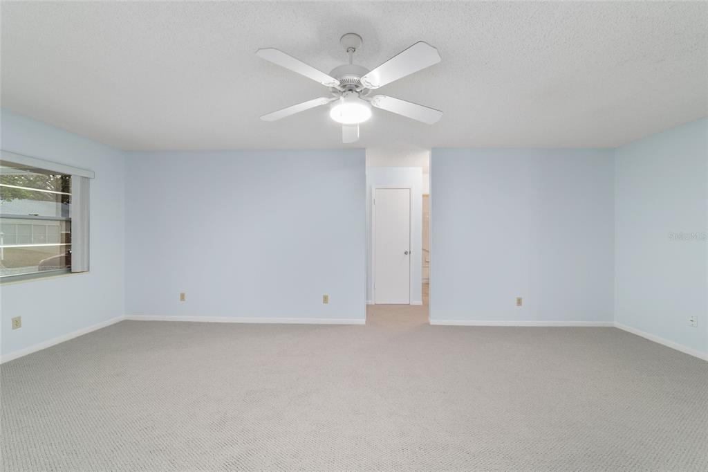 8890 Southwest 96th Street, Unit B Ocala, FL 34481 - Photo 9 of 42 an empty room with a window and ceiling fan