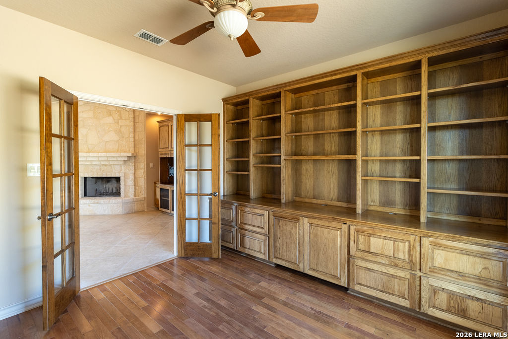 a hallway with cabinets a wooden floor and a window