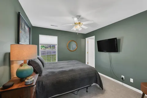 a bedroom with a bed and dresser with mirror