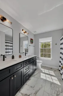 a spacious bathroom with double vanity and a large mirror