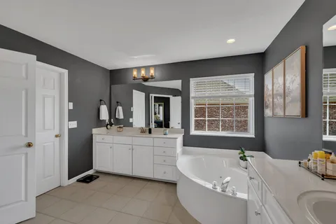 a bathroom with a tub sink and mirror