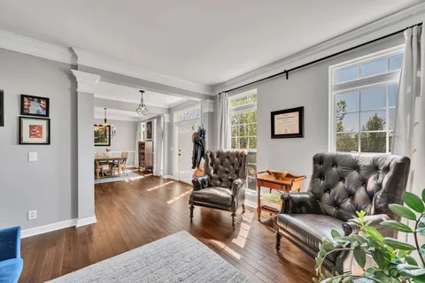 a living room with furniture wooden floor and a large window