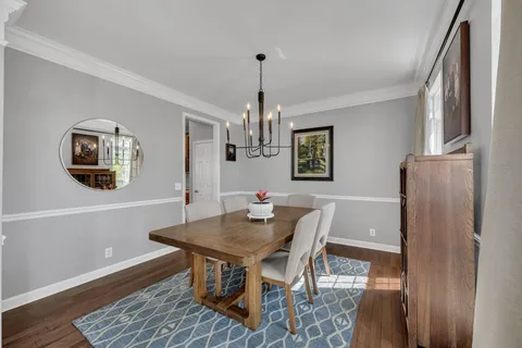 a dining room with furniture a rug and a chandelier