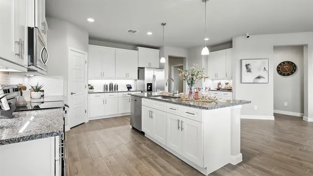 a kitchen with a dining table chairs sink and cabinets
