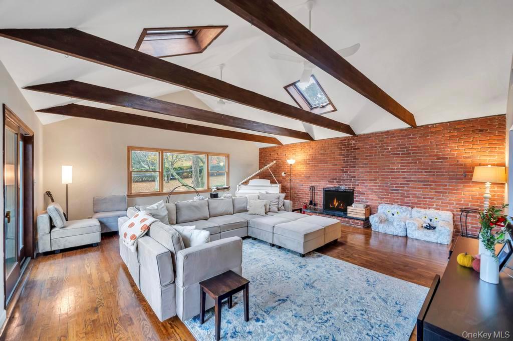 39 Bevin Road Northport, NY 11768 - Photo 18 of 44 Living area featuring brick wall, wood finished floors, a fireplace, and stairs