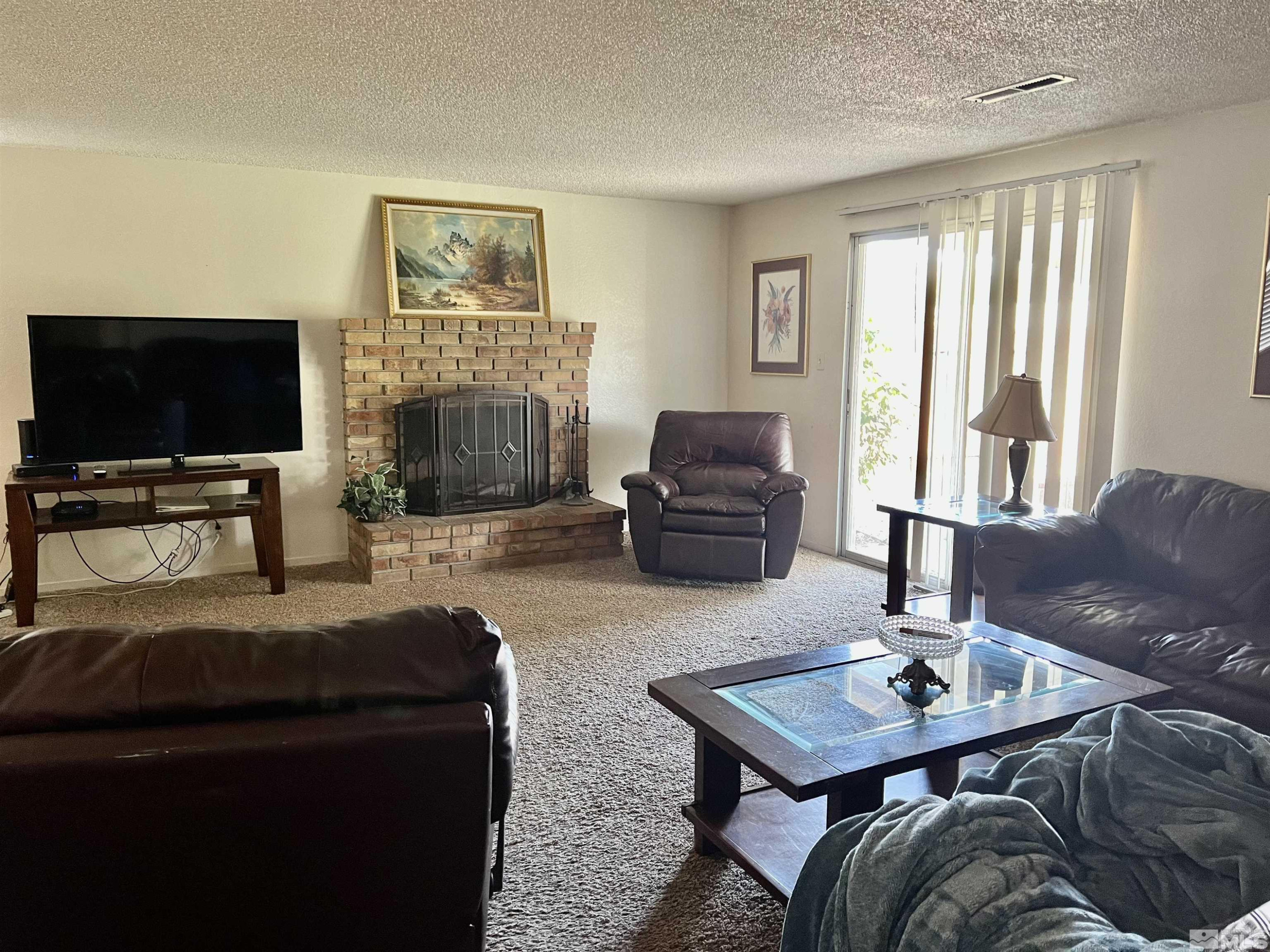 3020 Chavez Drive Reno, NV 89502 - Photo 4 of 15 a living room with furniture a flat screen tv and a fireplace