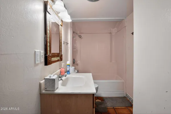 a bathroom with a sink vanity mirror and toilet
