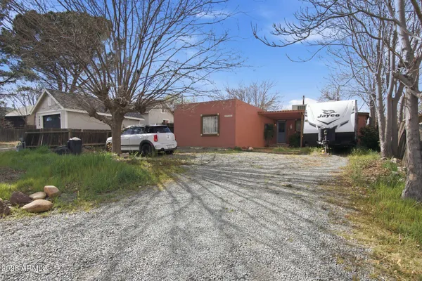 a front view of a house with garden and trees