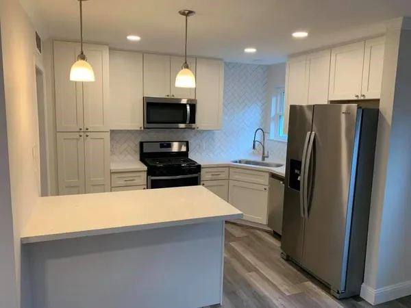 a kitchen with a refrigerator a microwave and stove top oven