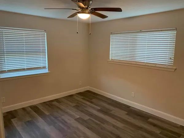 an empty room with a window and a ceiling fan