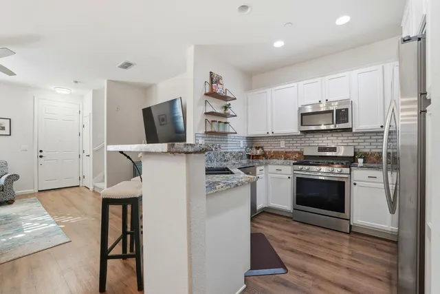 a kitchen with stainless steel appliances granite countertop a sink and cabinets