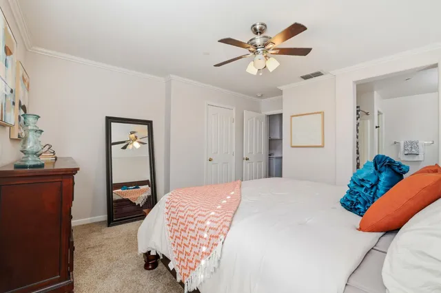 a bedroom with a bed ceiling fan and a window