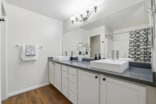 a bathroom with a double vanity sink a mirror and a bathtub