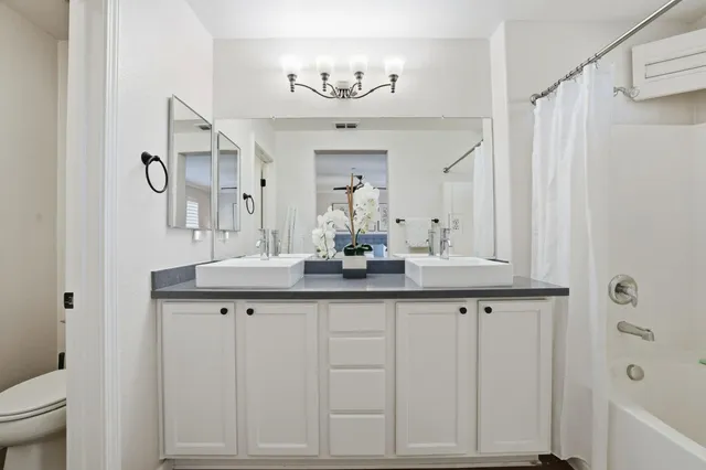 a bathroom with a granite countertop sink a mirror and a bathtub