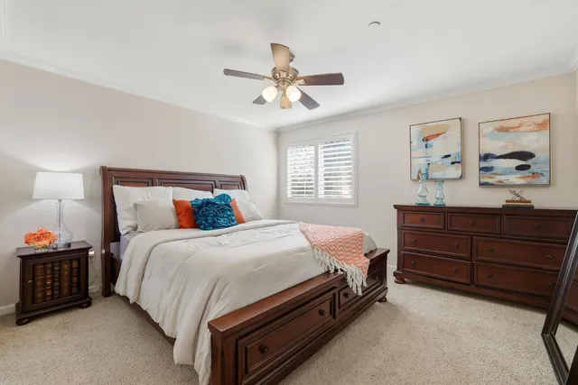 a living room with furniture a ceiling fan and a flat screen tv