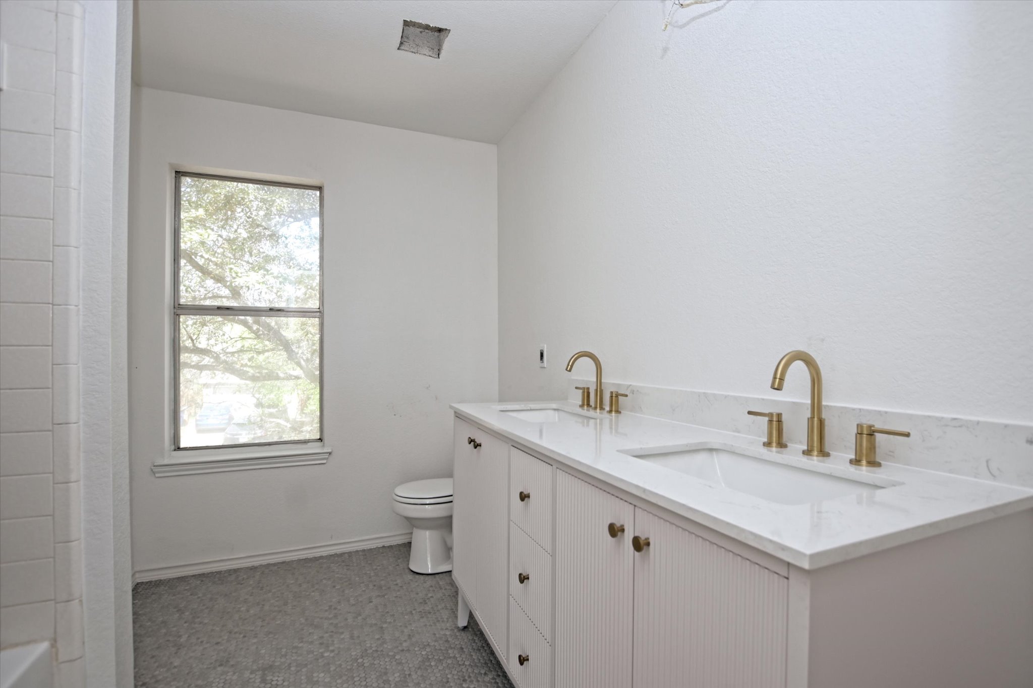 2509 Patsy Parkway Austin, TX 78744 - Photo 16 of 28 a bathroom with a granite countertop sink a toilet and a window