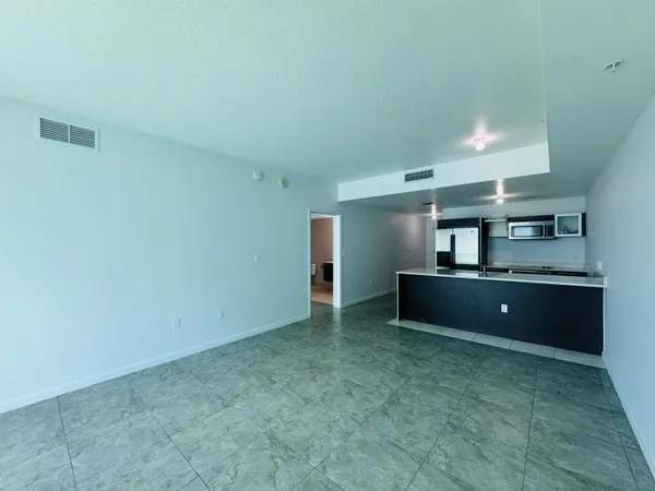 a living room with stainless steel refrigerator a sink
