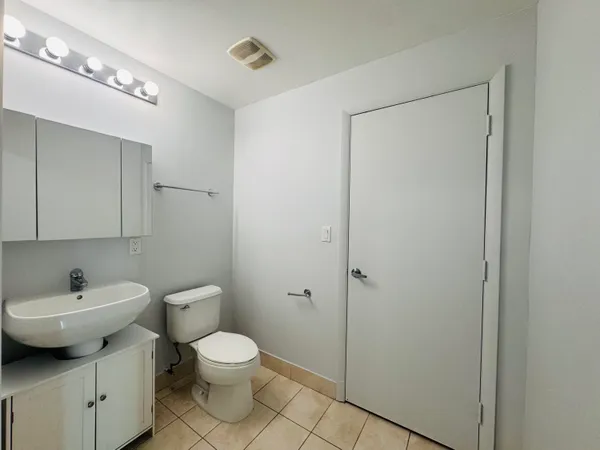 a bathroom with a toilet a sink and mirror