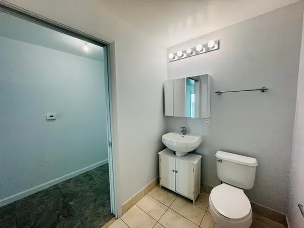 a bathroom with a toilet sink and mirror