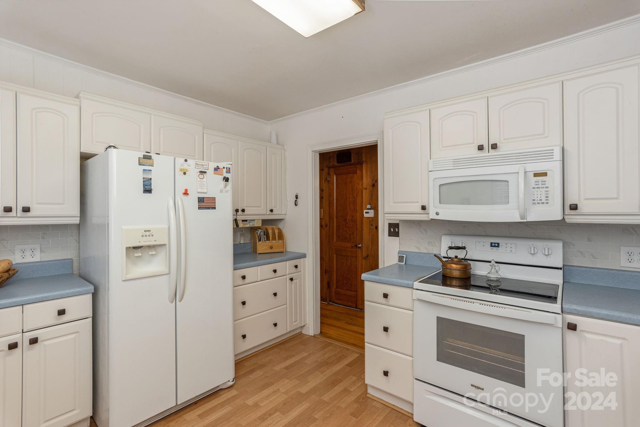 1489 Lynn Road Tryon, NC 28782 - Photo 17 of 46 a kitchen with white cabinets and refrigerator oven