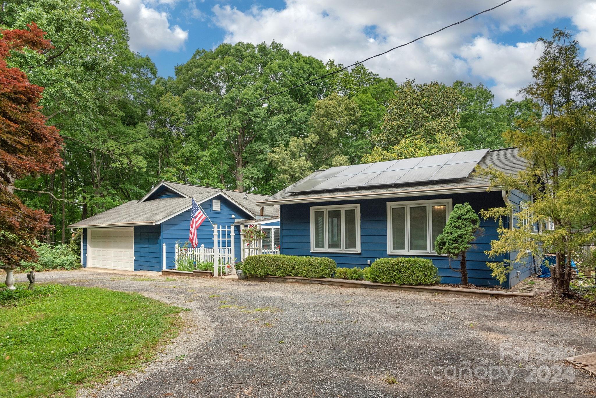 1489 Lynn Road Tryon, NC 28782 - Photo 5 of 46 a view of a house with a yard and potted plants