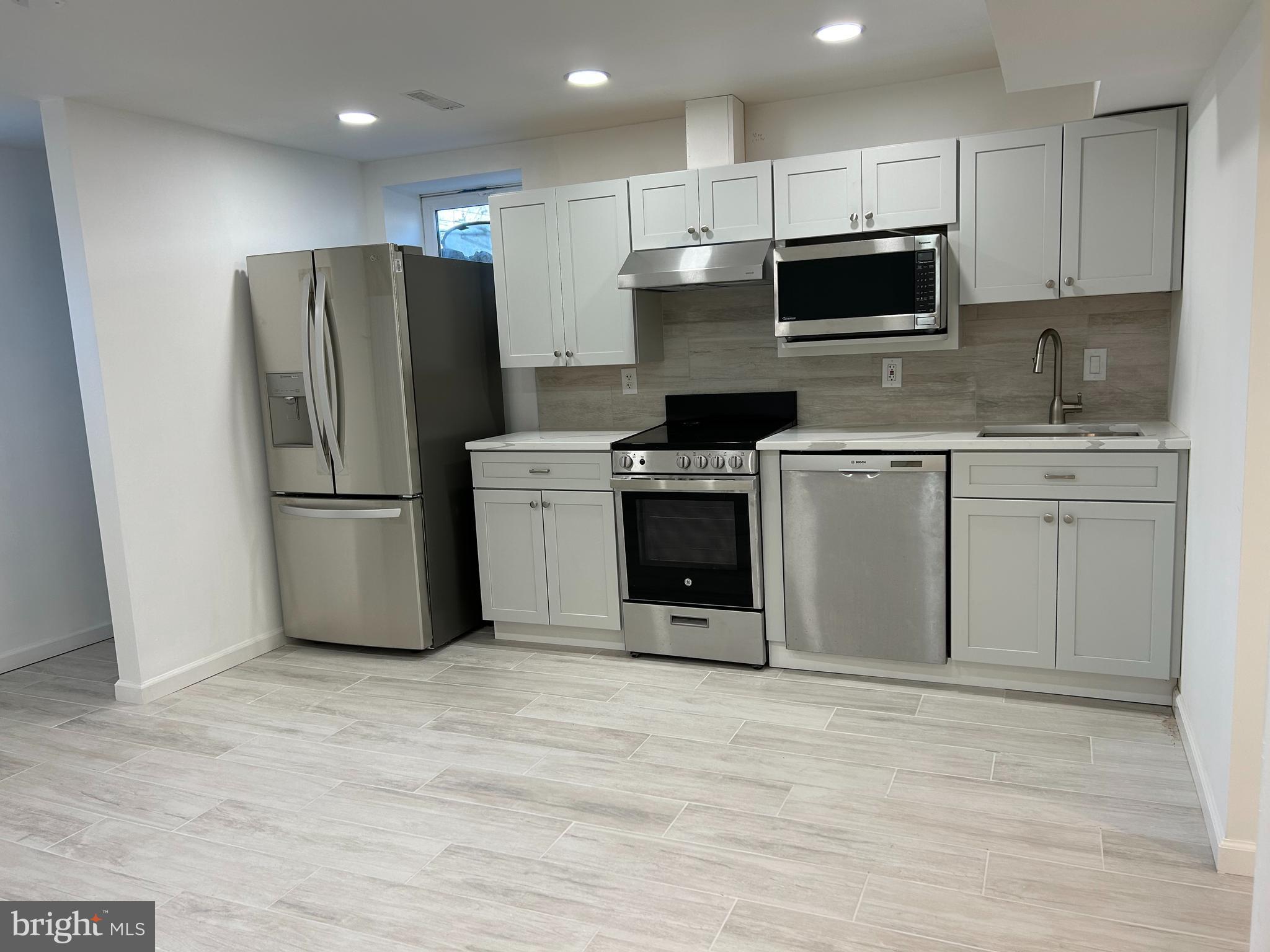 a kitchen with stainless steel appliances granite countertop a refrigerator stove a sink and a microwave