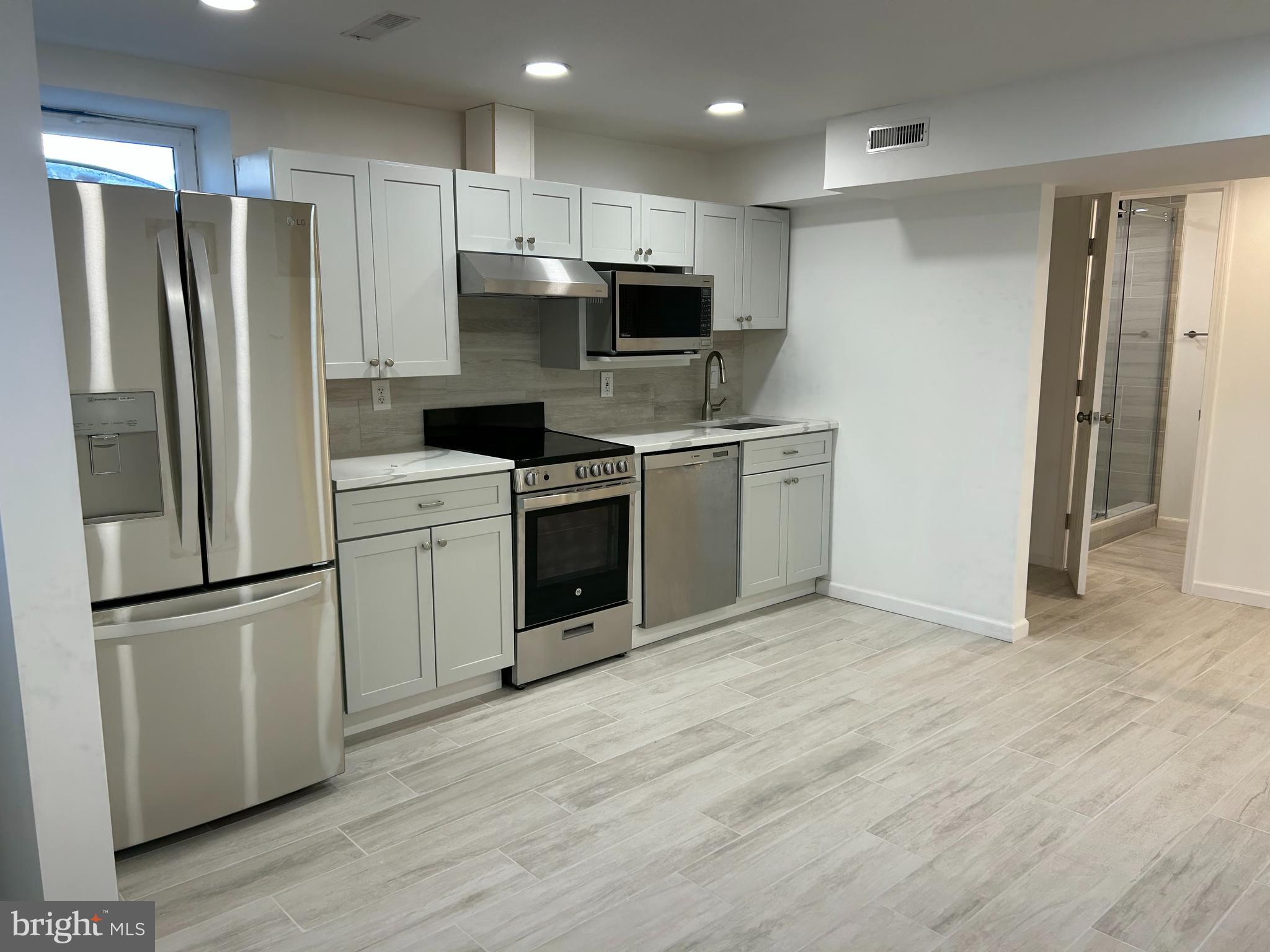 7131 Gormel Drive Springfield, VA 22150 - Photo 7 of 27 a kitchen with stainless steel appliances granite countertop a stove a refrigerator and a microwave