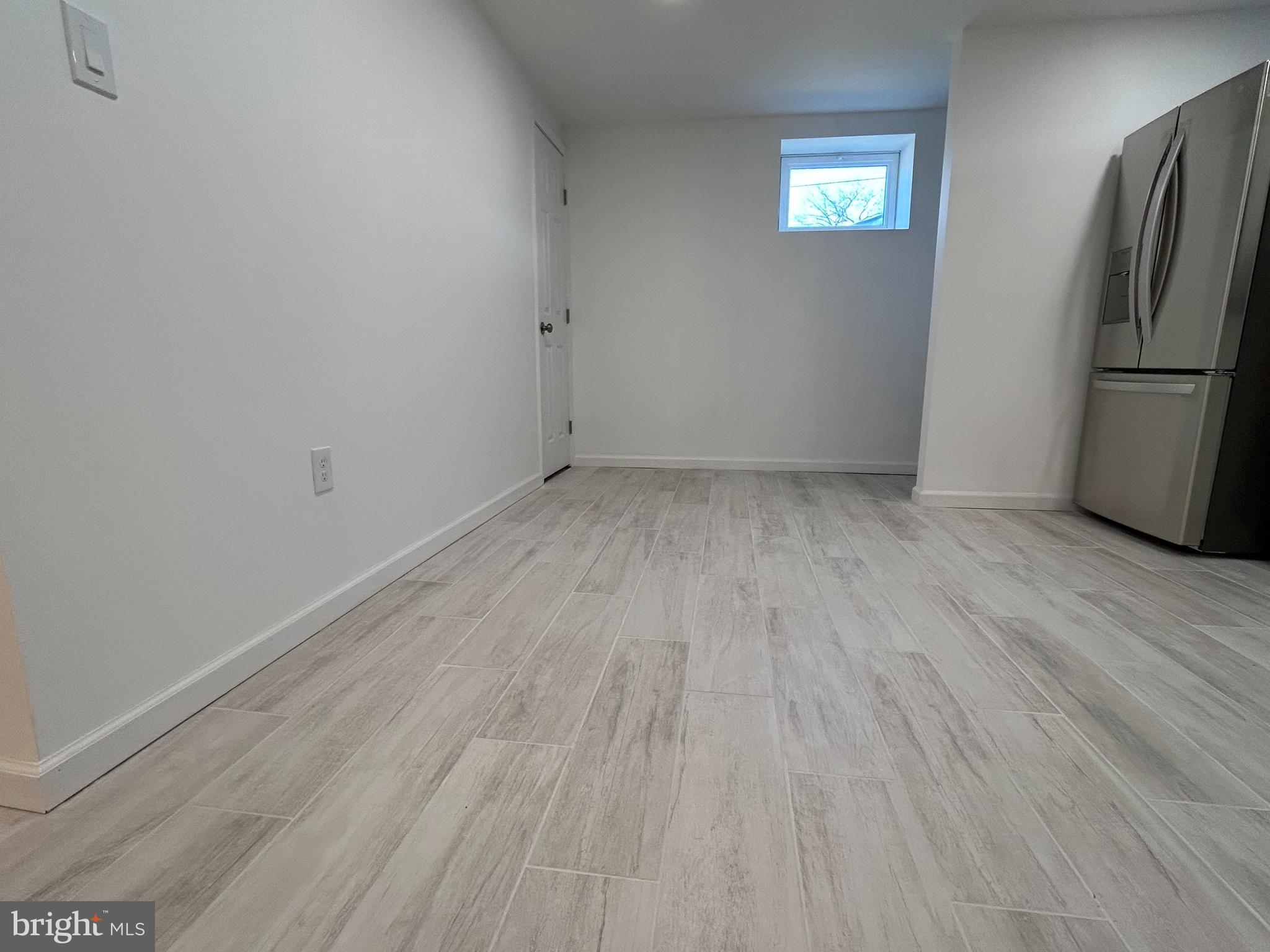7131 Gormel Drive Springfield, VA 22150 - Photo 8 of 27 a view of a room with wooden floor and a refrigerator
